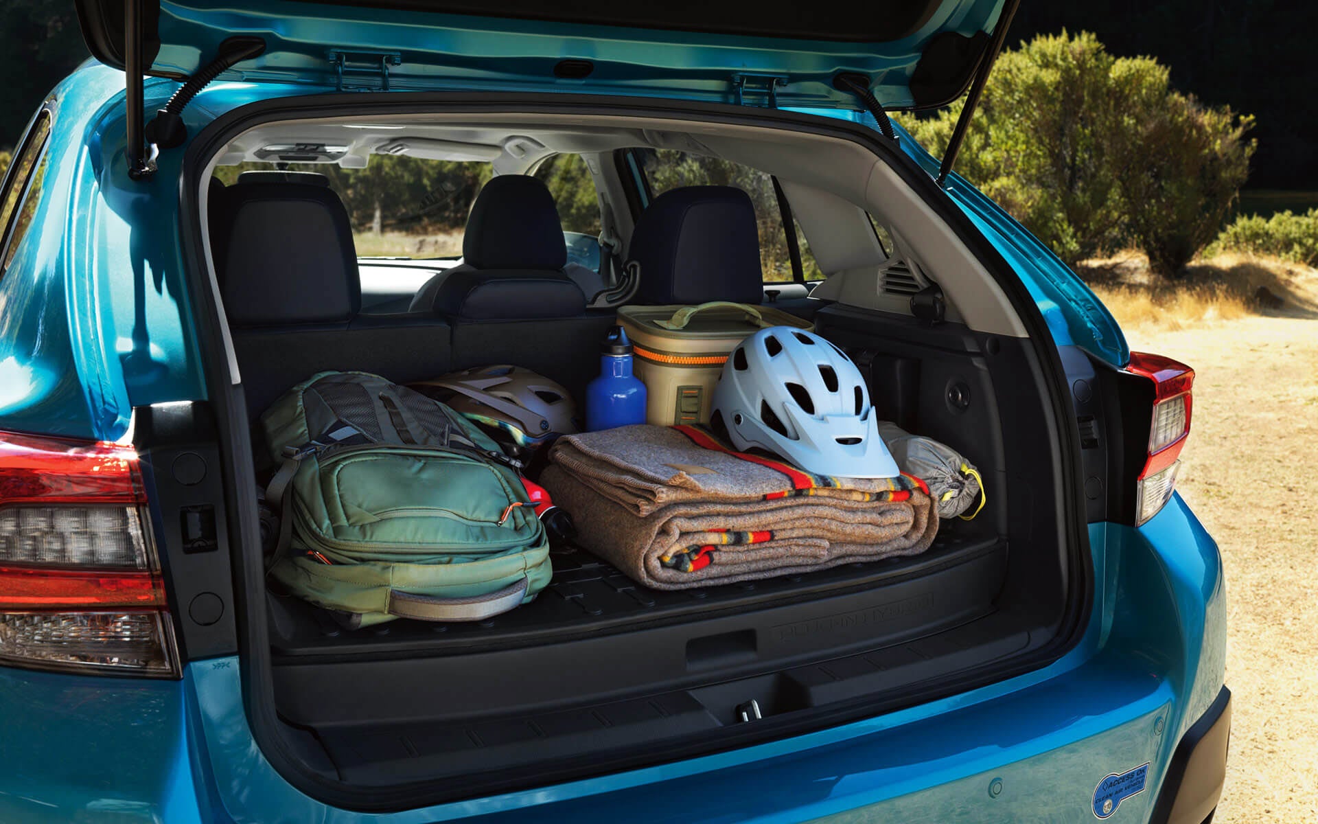 A backpack, blanket, and bike helmet in the rear cargo area of a Crosstrek Hybrid | River City Subaru in Huntington WV