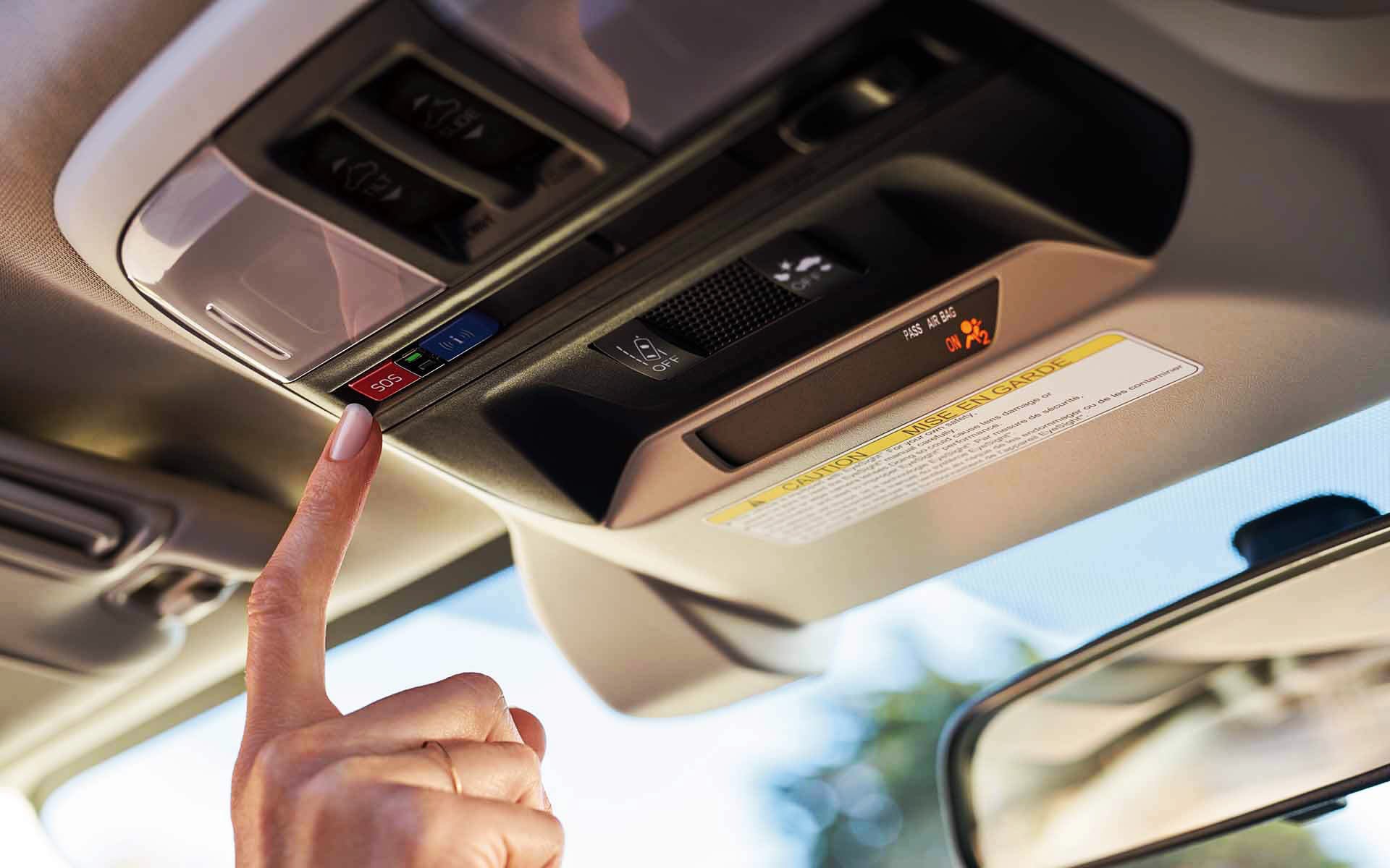A finger pressing the Crosstrek Hybrid's SOS emergency assistance button | River City Subaru in Huntington WV