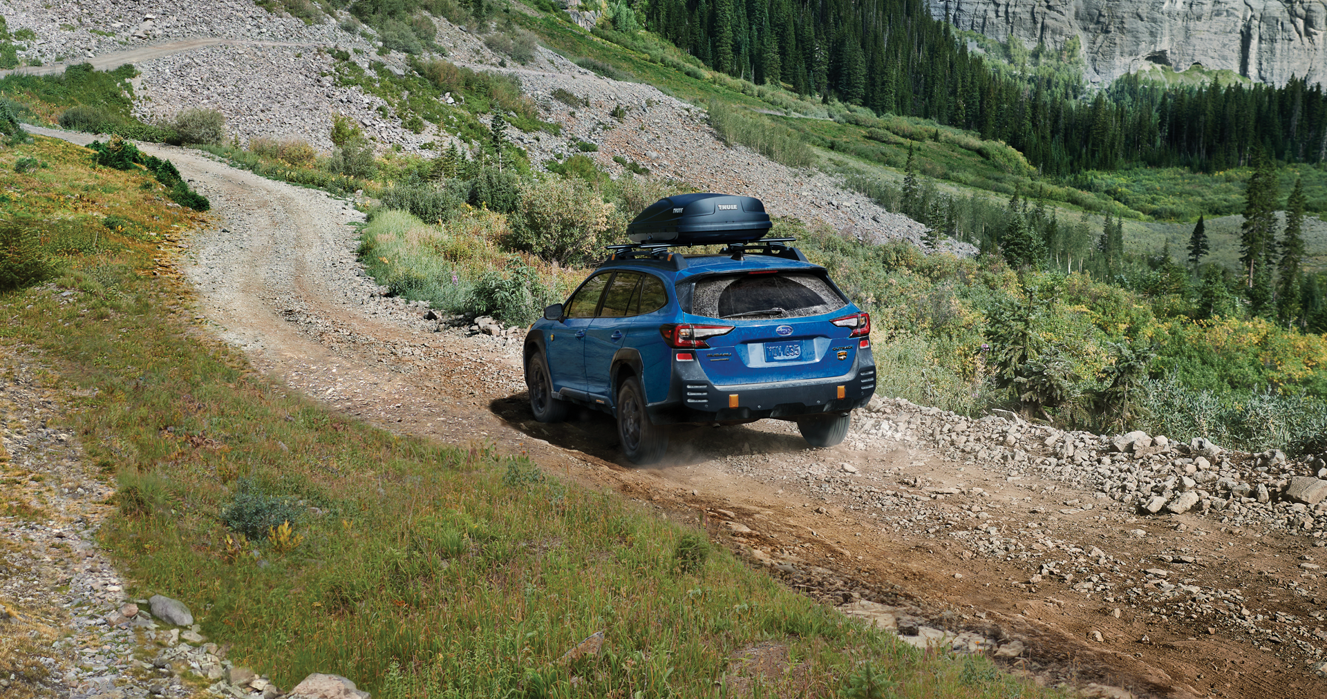 A 2023 Outback Wilderness driving on a trail in the mountains. | River City Subaru in Huntington WV