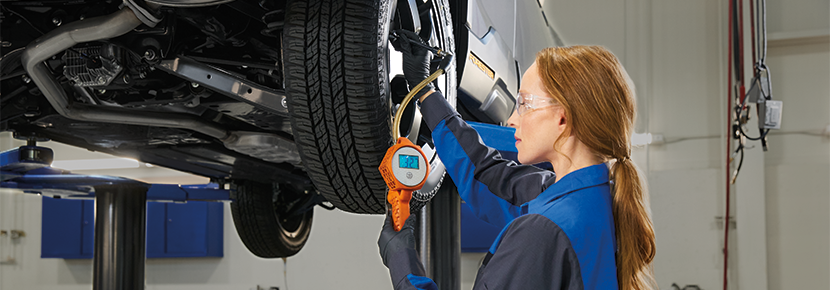 A Subaru technician checking tire pressure. | River City Subaru in Huntington WV